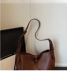 Detail view of the vintage dark brown leather tote bag with a smooth polished texture