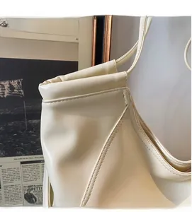 Détail du sac cabas en cuir PU crème avec plis élégants et coutures soignées