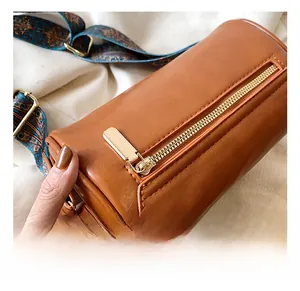 Dettaglio borsa a bauletto in ecopelle marrone con tracolla etnica blu e oro