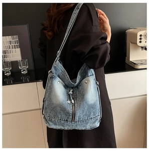 Détail du sac hobo en jean bleu vintage avec fermeture éclair et rivets