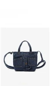 Front view of mini deconstructed denim crossbody bag with vintage metal button details