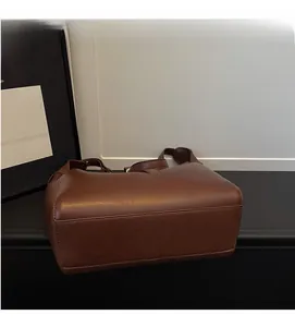 Detailed view of brown matte PU leather tote with premium stitching and a wide bottom