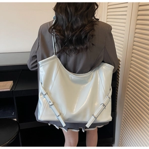 Grand sac cabas en cuir verni bleu clair avec boucles latérales réglables porté à l'épaule