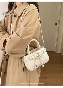 Chic cream leather crossbody bag with pleated bow and silver star pendant on model