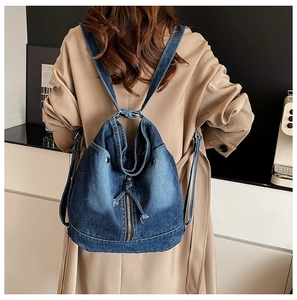 Gros plan d'un sac à dos en denim bleu délavé avec cordon sur un mannequin