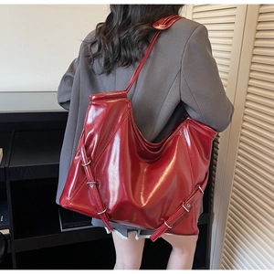Vue arrière détaillée d'un grand sac cabas rouge brillant avec boucles élégantes