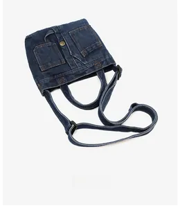 Detail of vintage denim shoulder bag showing metal buttons and jean pocket design