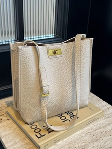 Borsa tote minimalista in pelle beige con grana e chiusura a girello in metallo dorato