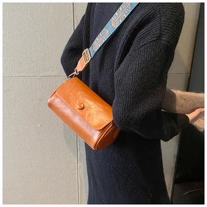 Dettaglio borsa bowling vintage in pelle PU marrone con tracolla etnica blu