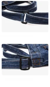 Detail of adjustable black metal strap buckle on dark blue denim fabric with orange stitching