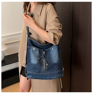 Détail d'un sac cabas rétro en denim avec texture délavée et finitions métalliques