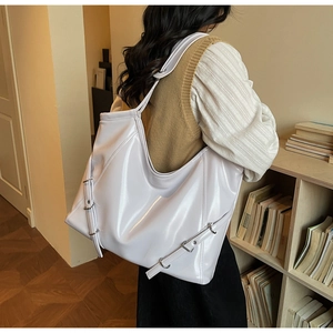 Détail du sac cabas blanc brillant avec boucles métalliques et sangles réglables