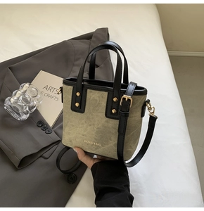 Dettaglio della mini borsa in tela retrò con finiture in pelle nera e borchie d'oro
