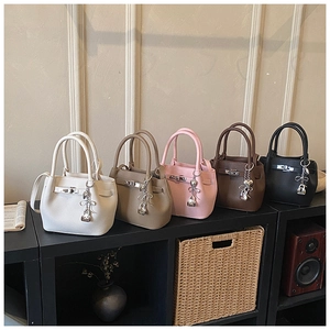 Detail of five mini bucket bags in leather with decorative bow charms and metal locks