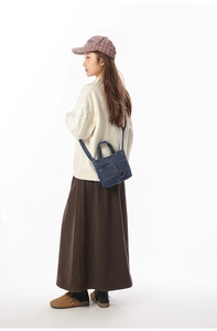 Detailed view of mini retro denim crossbody bag with dual utility pockets on model