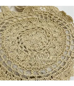 Detailed macro view of beige crochet straw bag featuring hollow floral weaving and fabric lining