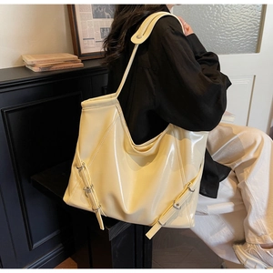 Détail d'un sac cabas jaune crème brillant avec boucle latérale et design spacieux