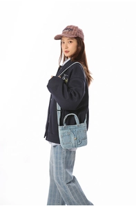 Close-up of denim bag showing jean pocket design with stitching and metal button details