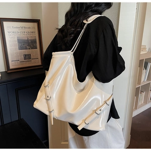 Détail d'un grand sac cabas en cuir verni crème avec boucles argentées pour le bureau