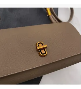 Detail of lychee pattern leather handbag featuring a gold rectangle turn-lock closure