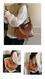 Detail view of a vintage brown leather bucket bag with decorative buckle and strap details