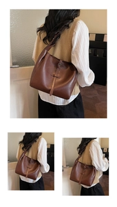 Detail of dark brown leather tote bag with stylish buckle strap and soft texture