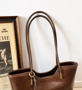 Detail of vintage brown tote bag long handle with golden adjustable metal buckle