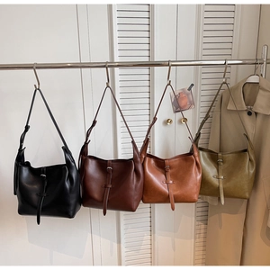 Detailed display of vintage tote bags in black, dark brown, caramel, and olive green colors