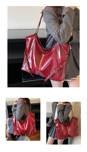 Détail d'un grand sac cabas rouge foncé avec cuir brillant et boucles métalliques décoratives