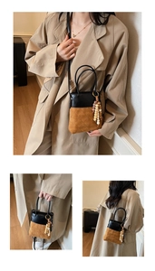 Detail of two-tone bucket bag with quilted suede, black leather, and wood bead tassel