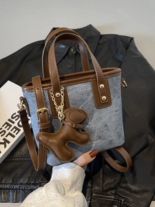 Borsa tote in denim alla moda con finiture in pelle marrone e ciondolo a forma di cucciolo