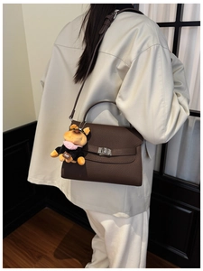 Detail of brown litchi pattern leather bag with silver twist lock and bulldog charm