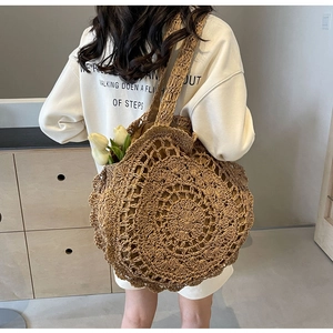 Detailed close-up of bohemian large-capacity woven straw shoulder bag with lace edges