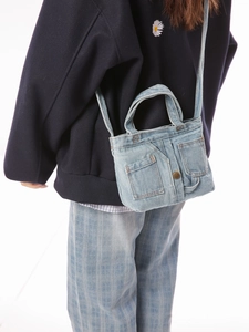 Retro denim crossbody bag with unique jeans design and metal button on white background
