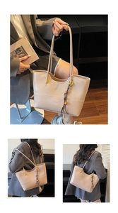 Detail of apricot faux leather tote bag featuring slim handles and beaded tassel charm