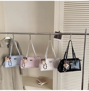 Detail view of four casual leather underarm bags in blue, pink, cream and black colors