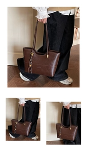 Detail of dark brown leather tote bag with elegant tassel charm and golden hardware