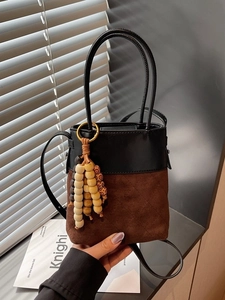 Minimalist bicolor bucket bag in black leather and brown suede with quilted patterns
