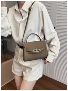 Deep brown litchi pattern leather handbag with silver lock shown on a model
