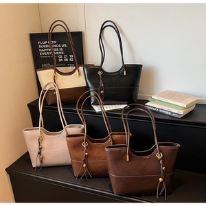 Five assorted vintage PU leather tote bags with tassel details in a luxury studio setup
