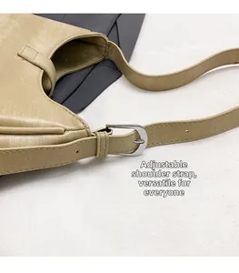 Detail of adjustable shoulder strap with silver metal buckle on beige leather handbag