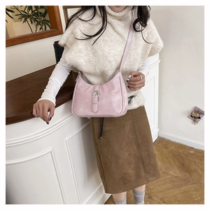 Pink crescent hobo bag with silver horseshoe buckle shown in an elegant interior setting