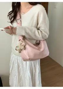 Pink hobo bag with wide shoulder strap and cute plush lamb pendant detail shot