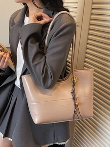 Minimalist milk tea PU leather tote bag with wood bead tassel shown on female model