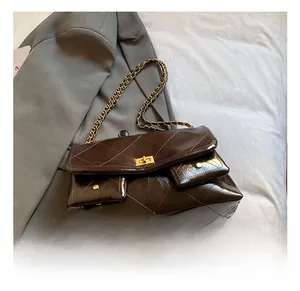 Detail of diamond quilted texture and golden twist lock on a brown chain tote bag