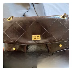 Macro detail of high-quality diamond quilted texture and golden turn-lock on the tote bag