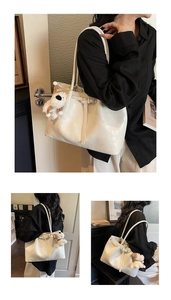Détail du grand sac cabas blanc brillant avec pendentif chiot peluche et boucle latérale