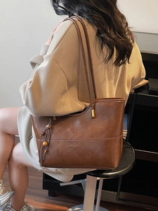 Brown vintage faux leather tote bag with tassel charm and slim shoulder straps