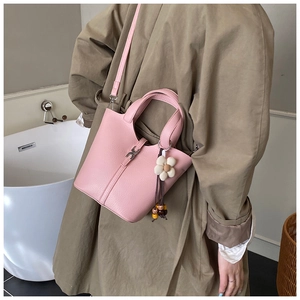 Detailed macro view of pink litchi leather bucket bag with floral bead charm detail
