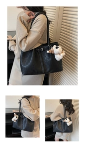 Détail d'un grand sac cabas noir en cuir mat avec un pendentif mignon en forme de chien peluche